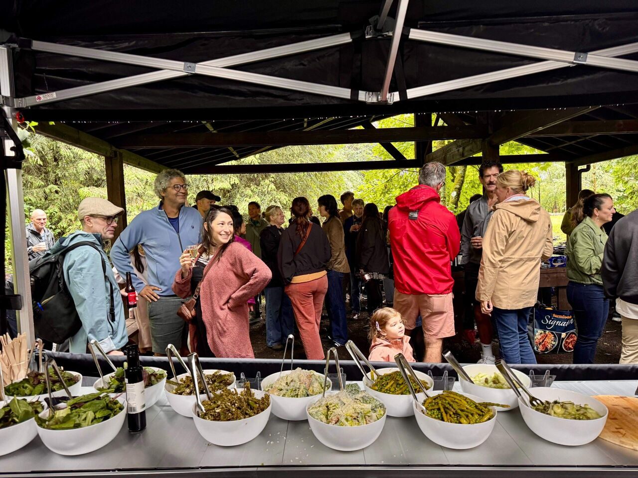 Party guests gathered round the Scottish Pizza Co sides buffet under a gazebo