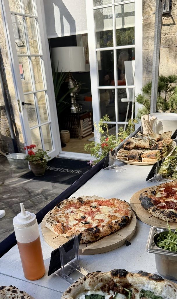 Scottish Pizza Co pizzas, salads and sides laid out on a sunny terrace table at Westpark